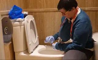 Ángela Paz, paciente ostomizada vaciando una bolsa en un baño normal | FAPOE