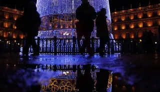 Personas caminando por la Plaza Mayor delante de la iluminación navideña | Foto: Andrea M.
