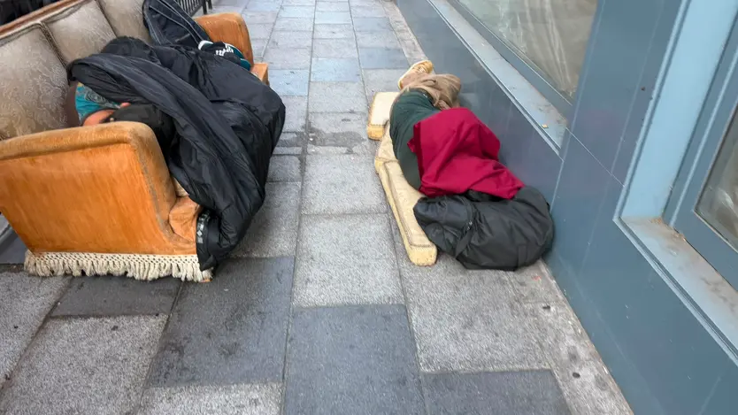 Dos varones duermen en un sofá en plena calle Álvaro Gil