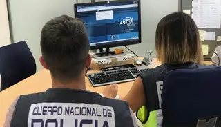 Agentes de la Policía delante de un ordenador. 