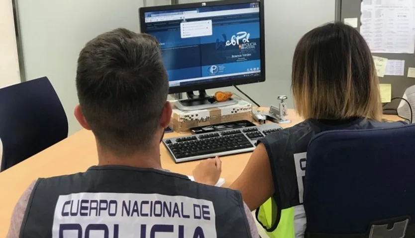 Agentes de la Policía Nacional delante de un ordenador