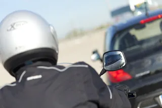 Un motorista detrás de un coche. Foto @DGTes
