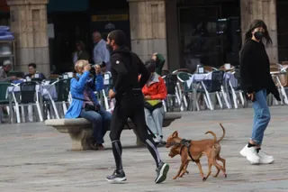 Un hombre corre junto a sus perros en la Plaza Mayor en un día otoñal