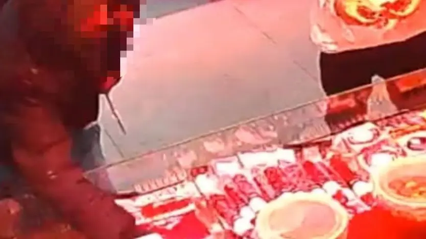 El momento exacto en el los dos ladrones roban los sobres de cecina