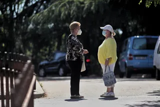 Dos mujeres protegidas con mascarilla mantienen una conversación en una de las calles del municipio de Griñón (Madrid) durante el día 69 del estado de alarma decretado a consecuencia del coronavir