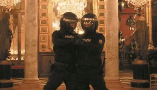 Imagen del cartel de la exposición: el tango entre dos antidisturbios en el marco del salón de baile de la casa Museo del Marqués de Cerralbo