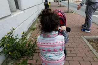 Una niña pasea por la calle empujando un carrito con un bebé de juguete junto a su padre y su hermano durante el segundo día de desconfinamiento de niños. En Madrid (España) a 27 de abril de 2020