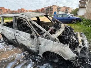 Coche calcinado en la calle La Uva, en el barrio de Chamberí