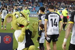 La mascota de Unionistas choca la mano con una niña antes del partido.