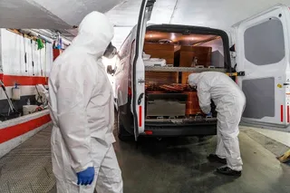 Dos operarios colocan ataúdes dentro de una furgoneta. | FOTO: ICAL