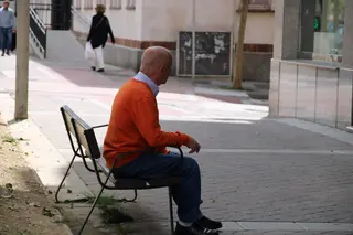 Un anciano sentado en un banco