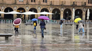Gente paseando por las Plaza Mayor de Salamanca con paraguas | D