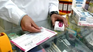 Archivo. Un farmacéutico consulta la receta de un paciente en una farmacia