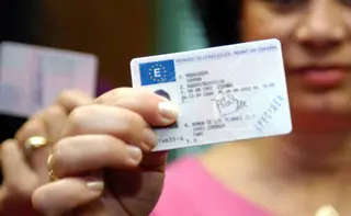 Una mujer muestra su carnet de conducir. | EP
