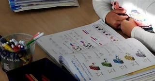 Un niño estudia con su libro de texto.