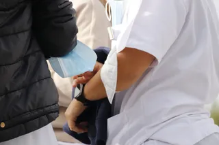 Dos personas portan mascarilla en sus brazos en el Hospital de Salamanca