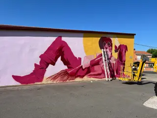 Uno de los muralistas trabajando sobre una pared en La Vellés 
