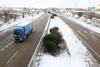 Camión circulando por una autovía con nieve