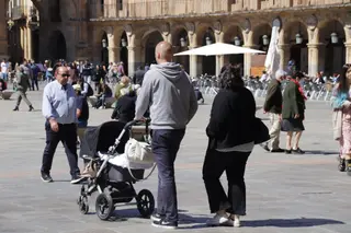 Gente por las calles de Salamanca con carrito de bebé