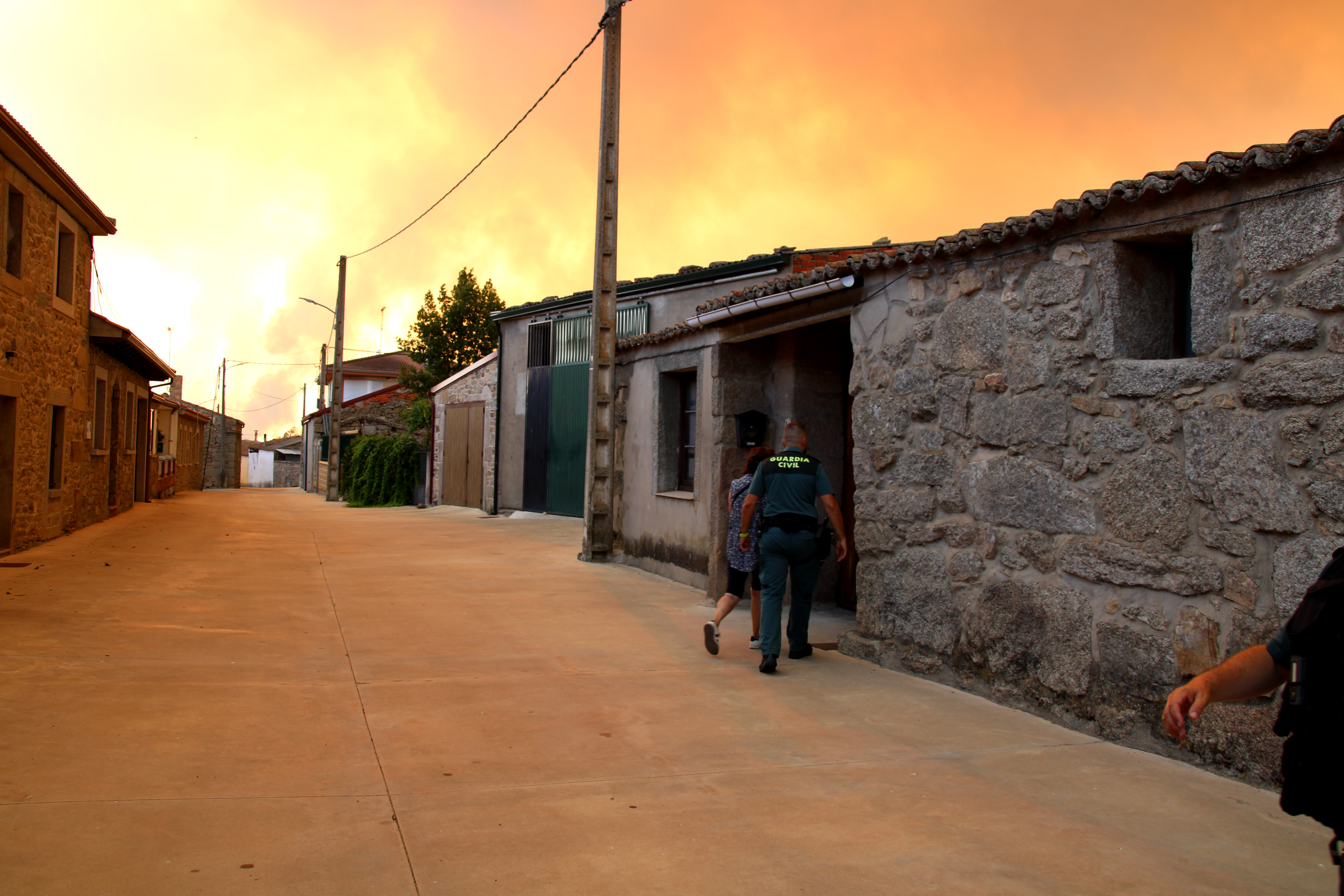 Un agente acude a ayudar a una vecina en Muga de Sayago durante la evacuaci&oacute;n