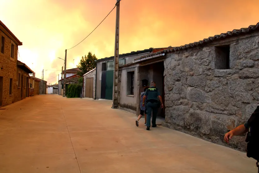 Un agente acude a ayudar a una vecina en Muga de Sayago durante la evacuación