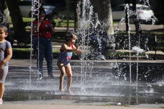 Niños jugando en la fuente del parque Alamedilla para evitar el calor