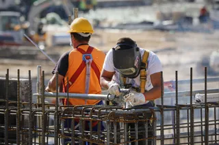 Dos obreros realizan trabajos de soldadura.