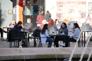 Terraza con gente en la Plaza del Oeste, otoño