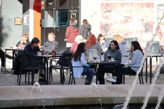 Terraza con gente en la Plaza del Oeste, otoño