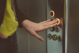 Una mujer pulsa el botón de un ascensor | Foto: EP