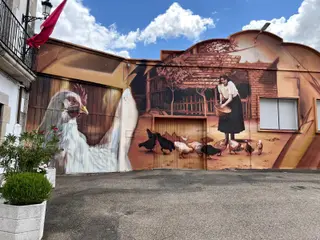 Mural de una mujer dando de comer a las gallinas en Cipérez, obra del artista salmantino Daniel Martín. Imagen Salamanca24horas