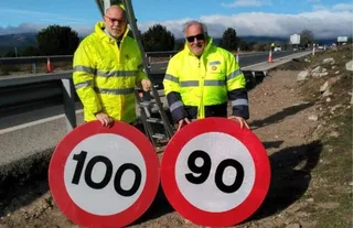 El director general de Carreteras, Javier Herrero; y el director general de Tráfico, Pere Navarro, cambiando la última señal que limita la velocidad a 100 km/h por la de 90 km/h en carreteras conve