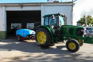 Un agricultor montado en su tractor saliendo de una nave. Foto EP