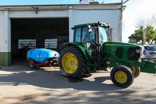 Un agricultor montado en su tractor saliendo de una nave. Foto EP