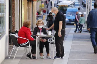 Dos mujeres toman café en una terraza de la avenida de Portugal
