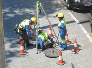 Seguridad en el trabajo, seguridad laboral, obreros con casco y chaleco reflectante, obra señalizada con conos, alcantarillado