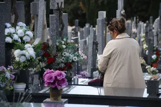 Gente visitando las tumbas de sus familiares en el cementerio
