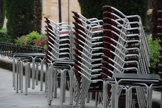 Mesas y sillas apiladas de la terraza de un establecimiento de la plaza de la Libertad