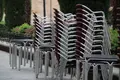 Mesas y sillas apiladas de la terraza de un establecimiento de la plaza de la Libertad