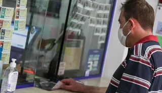 Un ciudadano compra un boleto para jugar a la Lotería