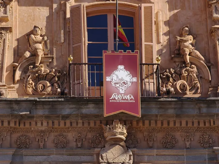 Reposteros en la fachada de la Plaza Mayor para dar la bienvenida al XXXVII Encuentro de Cofradías de Salamanca con el escudo de la Junta de Semana Santa